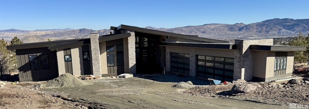 view of side of home with a mountain view and a garage