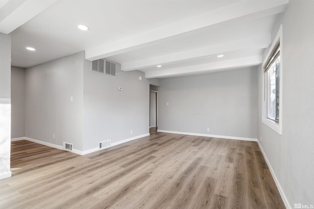 unfurnished room with beamed ceiling and light hardwood / wood-style flooring