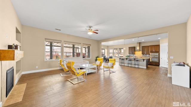 living room featuring hardwood / wood-style flooring, ceiling fan, and plenty of natural light