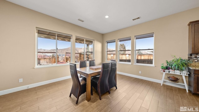 dining space with a mountain view and light hardwood / wood-style floors