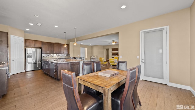 dining space featuring sink, ceiling fan, and light wood-type flooring