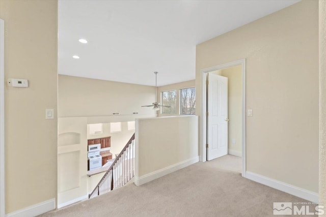 corridor featuring light colored carpet