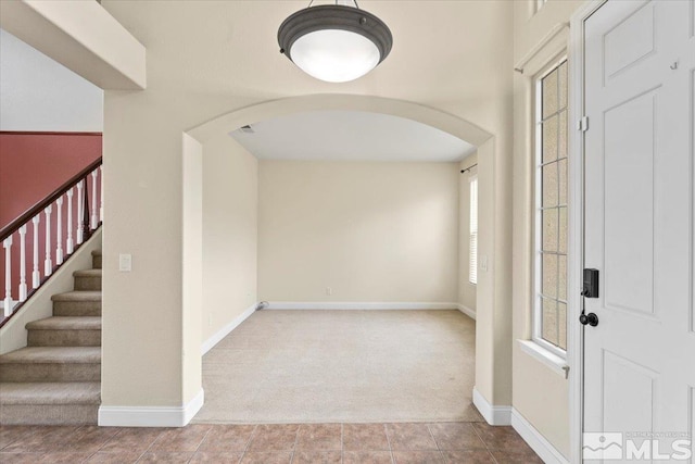 foyer entrance featuring light colored carpet