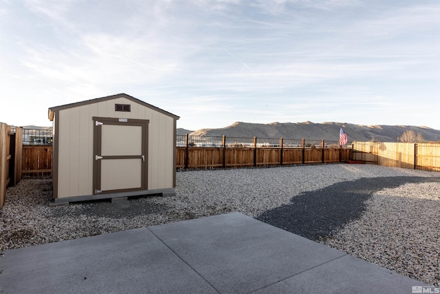 view of yard with a shed, a mountain view, and a patio