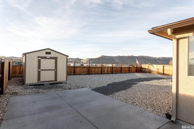 view of yard with a storage shed, a mountain view, and a patio