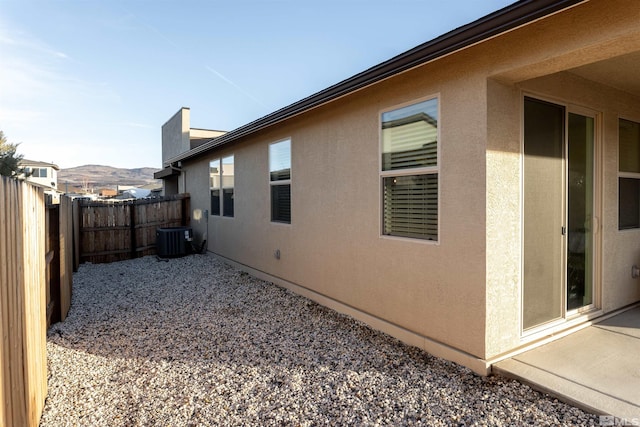 view of side of property featuring a mountain view and central AC unit