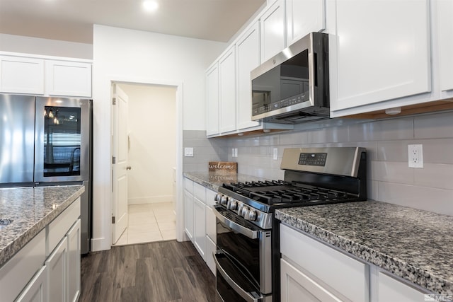 kitchen featuring backsplash, appliances with stainless steel finishes, stone countertops, and white cabinets