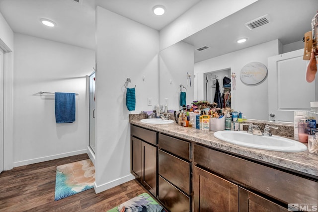 bathroom with wood-type flooring, an enclosed shower, and vanity