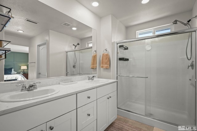 bathroom with vanity, an enclosed shower, and a textured ceiling