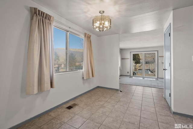 spare room with a mountain view, light tile patterned floors, and a chandelier