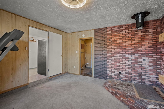 unfurnished living room with light colored carpet and wood walls