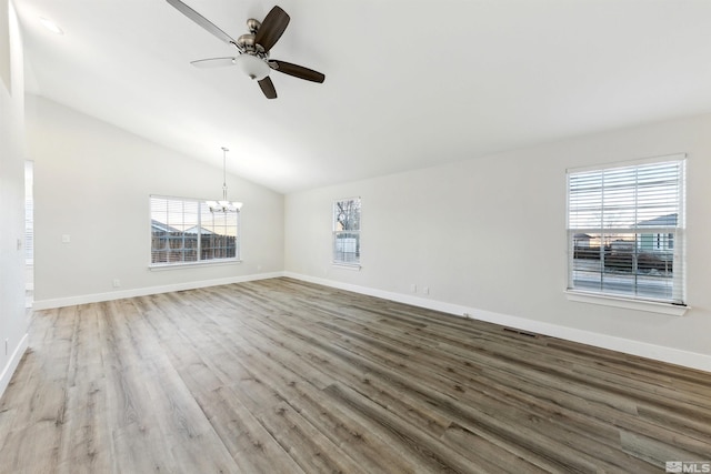 unfurnished room featuring ceiling fan with notable chandelier, lofted ceiling, and hardwood / wood-style floors