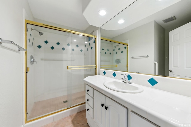 bathroom featuring tile patterned flooring, vanity, and walk in shower