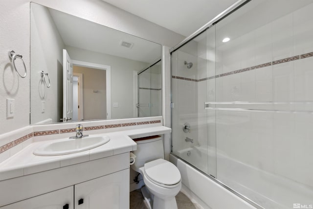 full bathroom with vanity, toilet, and combined bath / shower with glass door