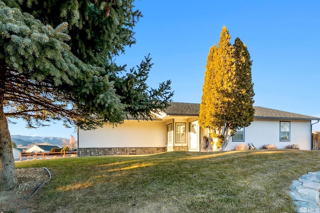 view of front of home with a mountain view and a front yard