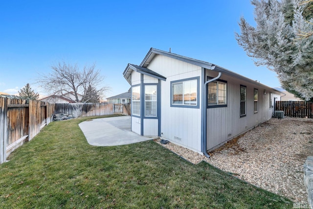 view of property exterior with central air condition unit, a patio, and a lawn