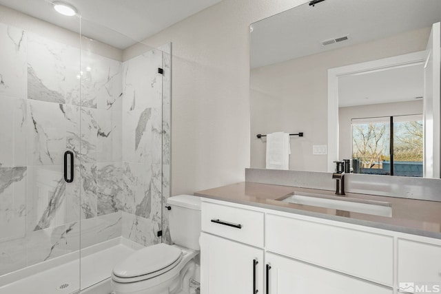 bathroom with vanity, toilet, and an enclosed shower