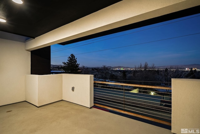 patio terrace at dusk featuring a balcony