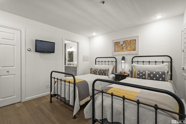 bedroom featuring dark wood-type flooring and ensuite bath