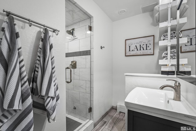 bathroom with a baseboard radiator, vanity, and an enclosed shower