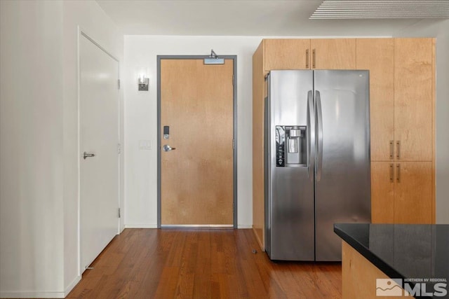 kitchen featuring light brown cabinetry, stainless steel fridge, and dark hardwood / wood-style flooring