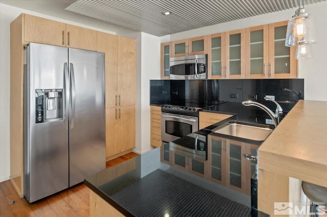 kitchen with appliances with stainless steel finishes, decorative light fixtures, sink, backsplash, and light brown cabinets