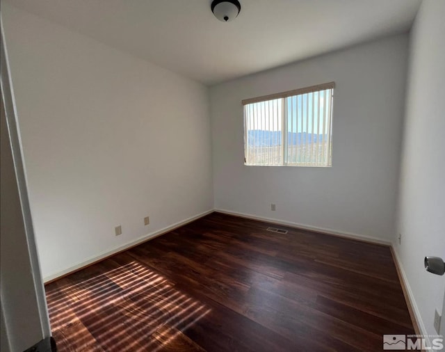 empty room featuring dark wood-type flooring