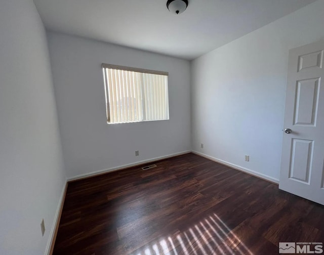 spare room featuring dark hardwood / wood-style flooring