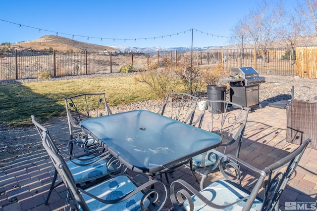 view of patio / terrace with a mountain view and a grill