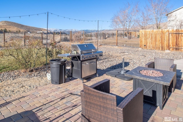 view of patio / terrace with a mountain view and a fire pit