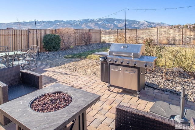 view of patio / terrace with a mountain view, area for grilling, and an outdoor fire pit