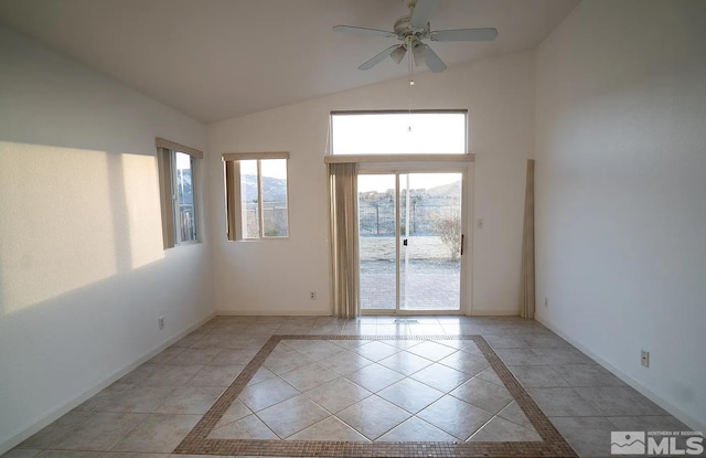 spare room featuring vaulted ceiling, light tile patterned floors, and ceiling fan