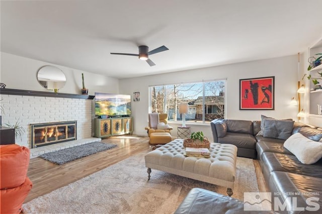 living room with ceiling fan, a fireplace, and hardwood / wood-style floors