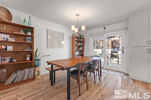 dining area featuring an inviting chandelier and light hardwood / wood-style flooring