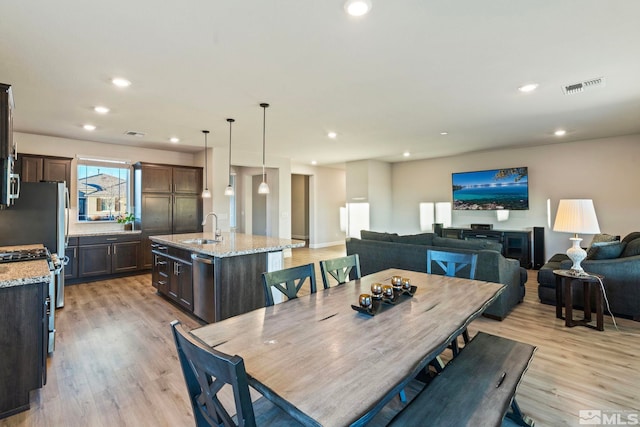 dining room featuring sink and light hardwood / wood-style floors