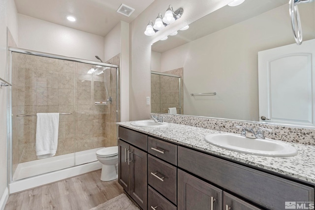 bathroom with walk in shower, wood-type flooring, toilet, and vanity