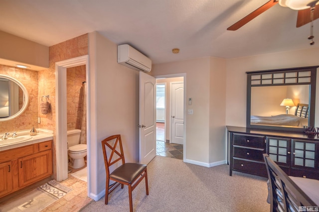 carpeted bedroom featuring ensuite bathroom, sink, a wall mounted AC, and ceiling fan