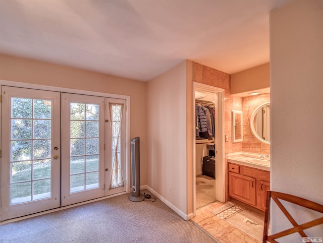 doorway to outside with french doors, sink, and light carpet