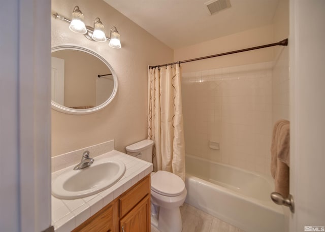 full bathroom featuring vanity, shower / bath combination with curtain, and toilet