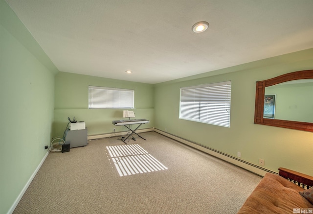 misc room featuring a baseboard heating unit and light colored carpet