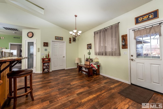 entryway with vaulted ceiling, dark wood-type flooring, and a notable chandelier