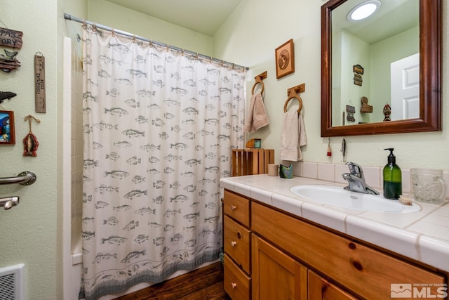 bathroom with vanity, wood-type flooring, and shower / bath combo with shower curtain