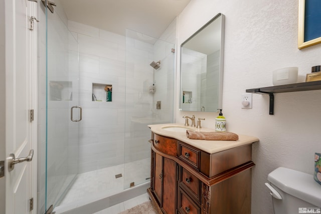 bathroom with vanity, an enclosed shower, and toilet