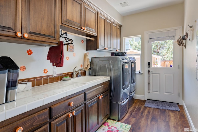 washroom with cabinets, dark hardwood / wood-style flooring, sink, and washer and clothes dryer