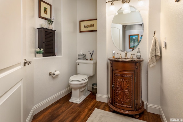 bathroom with vanity, toilet, and hardwood / wood-style floors