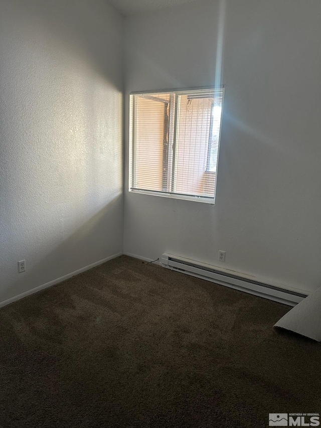 carpeted spare room featuring baseboard heating