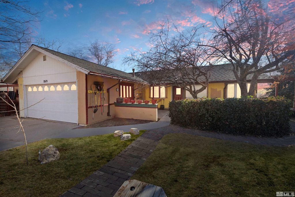 view of front facade featuring a garage and a yard