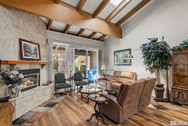 living room with a high end fireplace, lofted ceiling with beams, and hardwood / wood-style floors