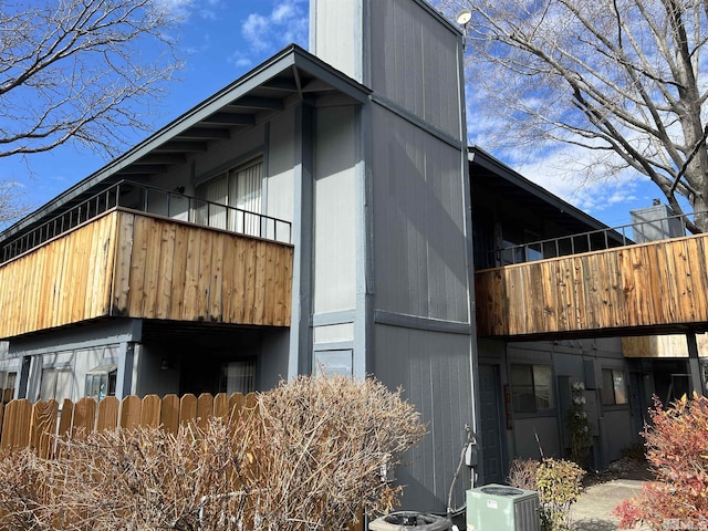 view of side of property with central AC unit and a balcony