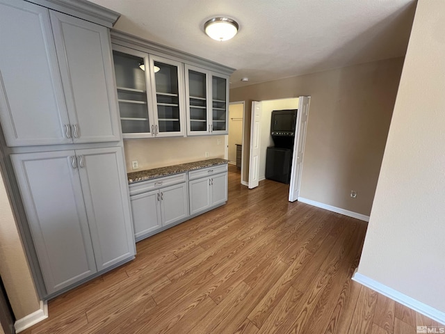 kitchen featuring dark stone counters, light wood-type flooring, and gray cabinetry